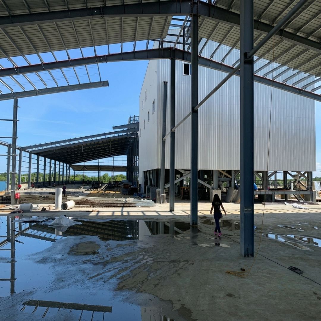 Interior construction view showing the 30 MT/hr feed mill building and adjacent covered bay.